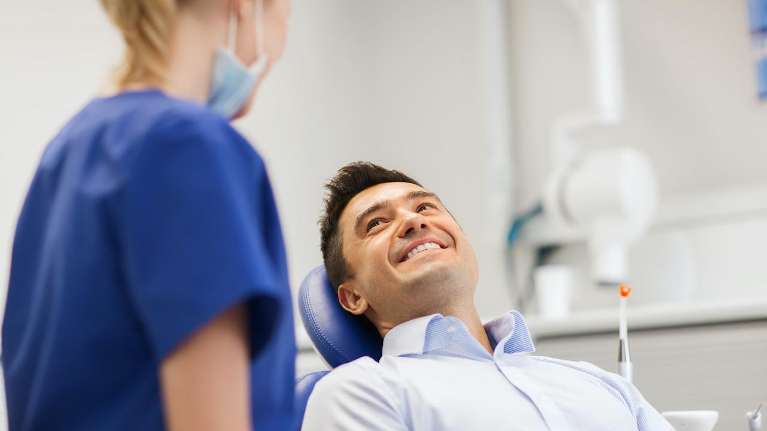 Male patient in Prosper TX smiling after dental implant 