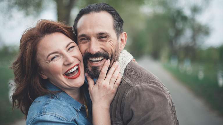 A couple laughing with their full set of teeth in Prosper TX