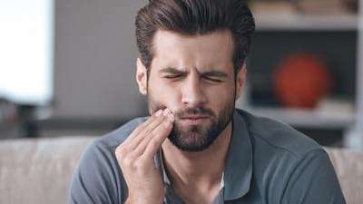 Man suffering from tooth pain in Prosper, TX